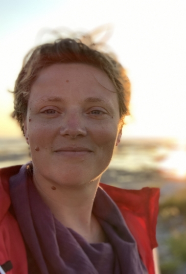 Image of author standing in front a sunset